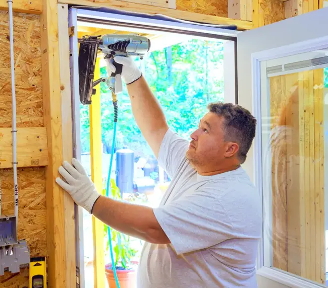 carpenter-is-using-pneumatic-nail-gun-to-install