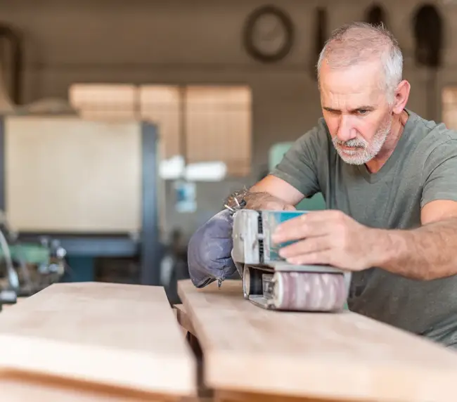 male-person-focused-working-with-a-hand-sander