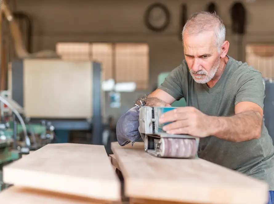 male-person-focused-working-with-a-hand-sander