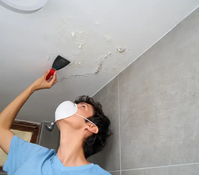 young-man-fixing-damp-and-saltpeter-problem